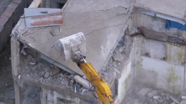 Destruindo a antiga casa de concreto usando braço mecânico de escavadeira no canteiro de obras — Vídeo de Stock