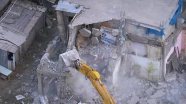 İnşaat alanındaki kova kazıcıyı kullanarak Eski Ev 'i yok etmek.