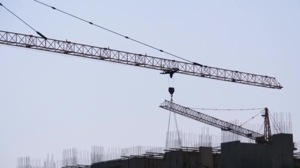 Tower Crane en un sitio de construcción levanta una carga en un edificio de gran altura. Cronograma — Vídeos de Stock