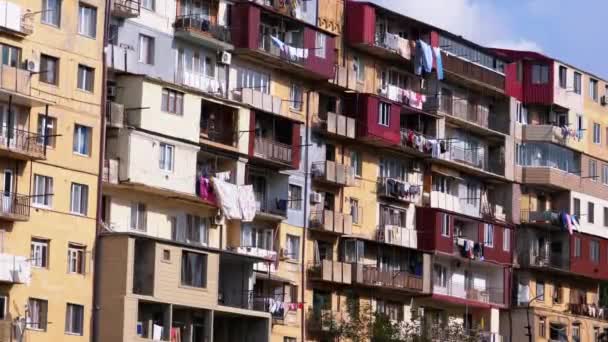 Одежда висит и сушится на веревке на многоэтажном здании в бедном районе города — стоковое видео