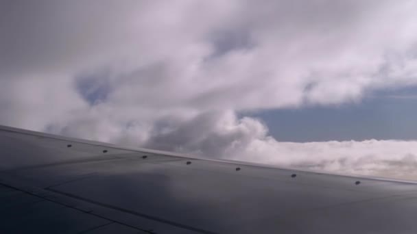 Vista desde la ventana de un avión de pasajeros en el ala y nubes en el cielo — Vídeo de stock