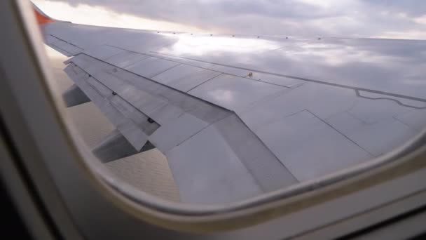 Blick aus dem Fenster eines Passagierflugzeugs auf die Tragfläche und Wolken am Himmel — Stockvideo