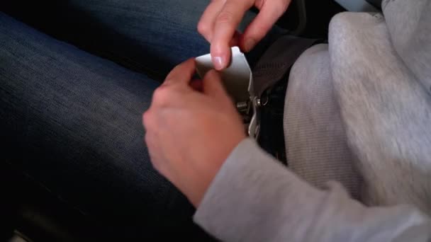 Femmes mains attacher et détacher un verrou de ceinture de sécurité dans la cabine d'un avion de passagers . — Video