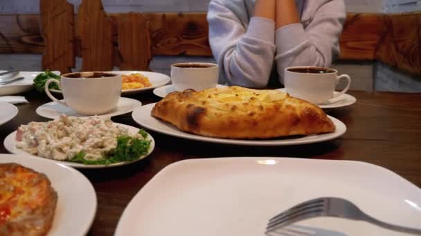 Adjarian Khachapuri na stole v gruzínské restauraci vedle salátu, omelety a kávy — Stock video