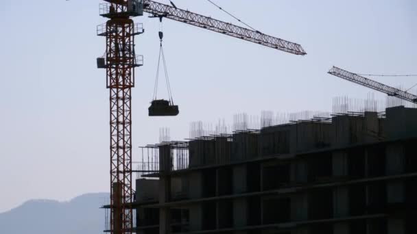 Construction de bâtiments. Grue à tour sur un panneau mural de levage de chantier de construction — Video