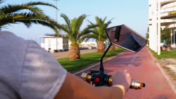 Kadın, tatil köyünde Palmiye ağaçlarıyla Kırmızı Bisiklet Yolunda Elektrikli Scooter sürüyor. — Stok video