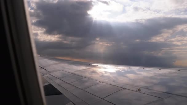 Vista da janela de um avião de passageiros na asa e nuvens no céu — Vídeo de Stock