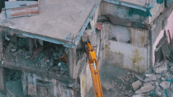 Vernietigen van het oude huis met behulp van emmer graafmachine op bouwplaats. Langzame beweging. — Stockvideo