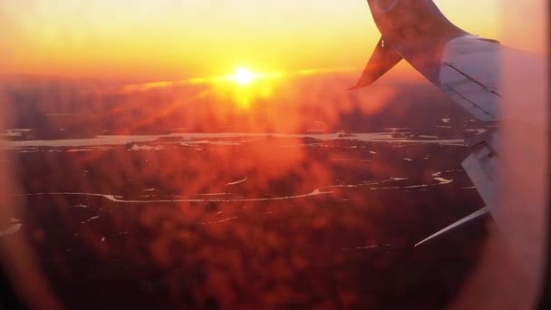 Θέα από το παράθυρο του αεροπλάνου στην πτέρυγα κατά τη διάρκεια του ηλιοβασιλέματος — Αρχείο Βίντεο