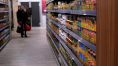 Süpermarkette çeşitli ürünlerle sıralar ve raflar. Alıcılar Ürünü Seçer.