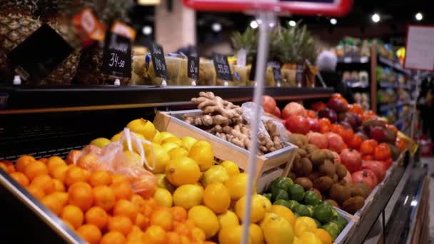 슈퍼마켓에서 가격 태그가 붙은 과일 부서와 구매자들이 지나가는 — 비디오