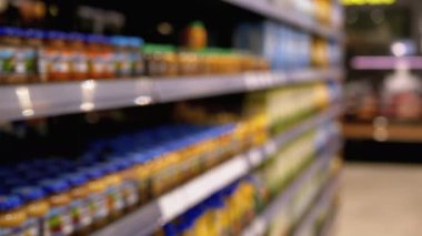 Süpermarkette çeşitli ürünlerle sıralar ve raflar. Alıcılar Ürünü Seçer.