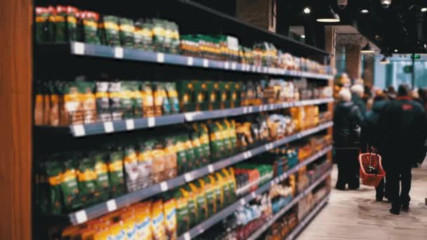 Linhas e prateleiras com vários bens no supermercado. Compradores escolhem o produto . — Vídeo de Stock