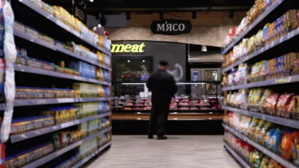 スーパーの様々な製品と行と棚。バイヤーは製品を選択. — ストック動画