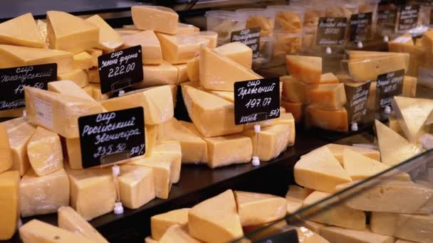 Olika hackade bitar av ost med prislappar på en monter i en butik — Stockvideo