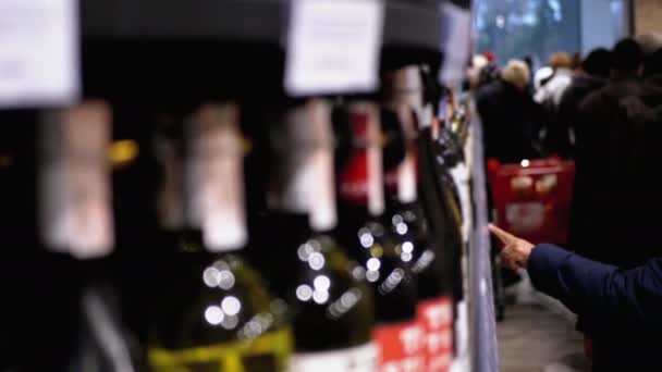 Kupujący wybierają napoje alkoholowe na półkach supermarketu w dziale Wina i Wódki — Wideo stockowe