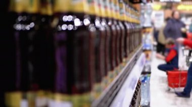 Süpermarkette alkol indirimi. Bir Mağaza Penceresinde Sıralar ve Raflar dolusu Şişe Birası