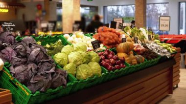 Süpermarket raflarında Fiyat etiketli taze sebzeler. Lahana, soğan, patates, balkabağı dükkanda satılıyor..