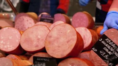 Marketteki Vitrinde Fiyat etiketli sosisler. Satıcılar Süpermarkette Tezgâhın Arkasında Duruyor