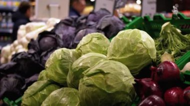 Süpermarket raflarında Fiyat etiketli taze sebzeler. Lahana, soğan, patates, balkabağı dükkanda satılıyor..