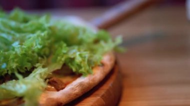 Restoranda yakın planda, tahta tepside, masa üstünde pizza. Malzemelerin ayrıntılı görünümü