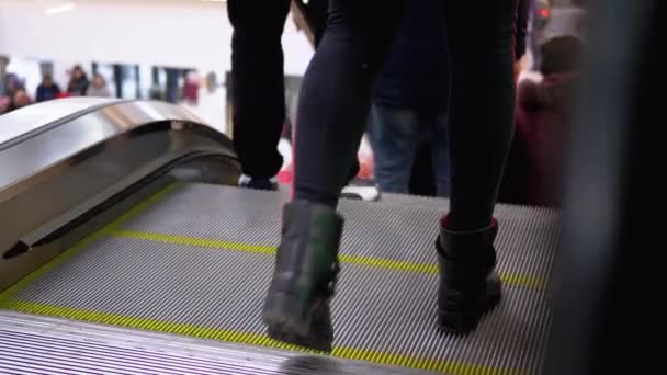 "Ноги людей двигаются на лифте эскалатора в торговом центре". Ноги покупателей на эскалаторе в торговом центре — стоковое видео