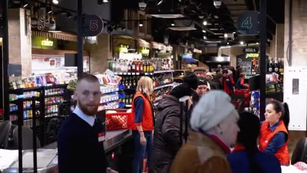 Толпа покупателей в супермаркете стоят в очереди на кассе — стоковое видео