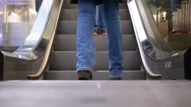 Pernas de pessoas que se movem em um elevador de escada rolante no shopping. Pés de compradores em escada rolante no centro comercial — Vídeo de Stock