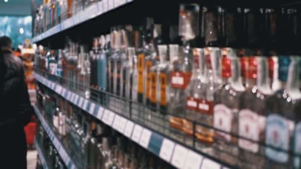 スーパーマーケットでのアルコール販売。ストアウィンドウ内のボトル入りアルコールの行と棚 — ストック動画