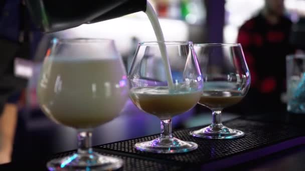 Barkeeper gießt an der Bar einen Cocktail in die Gläser — Stockvideo