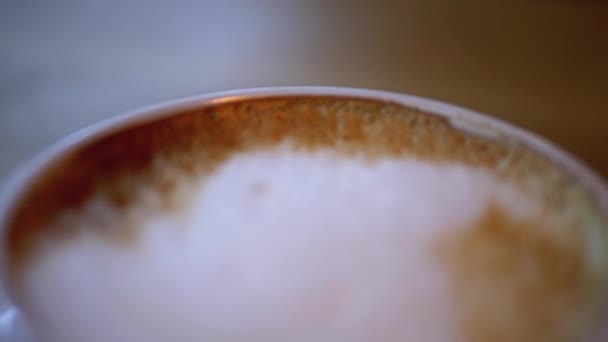 Copa de Cappuccino con Espuma Blanca en la Mesa de Madera del Restaurante. Primer plano — Vídeos de Stock
