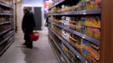 Süpermarkette çeşitli ürünlerle sıralar ve raflar. Alıcılar Ürünü Seçer.