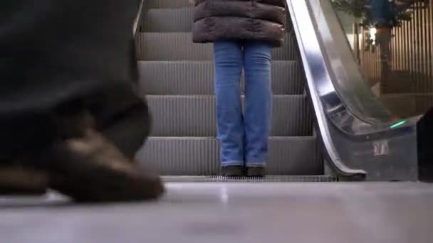 Beine von Menschen, die sich auf einer Rolltreppe im Einkaufszentrum bewegen. Shopper auf Rolltreppe in Einkaufszentrum — Stockvideo