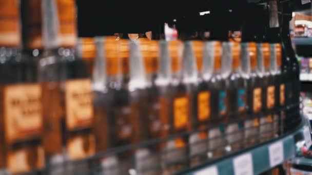 Vendita di alcolici al Supermercato. Righe e scaffali di alcol in bottiglia in una finestra del negozio — Video Stock