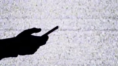 TV ekranında Beyaz Statik Gürültülü Akıllı Telefonu Tutan Bir Elin Silueti