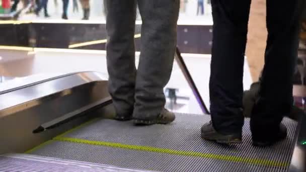 Piernas de gente moviéndose en un elevador de escaleras mecánicas en el centro comercial. Compradores Pies en escalera mecánica en el centro comercial — Vídeos de Stock