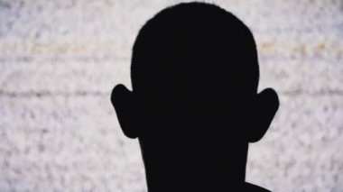 İsimsiz bir Mans Head 'in Silueti Beyaz Statik Gürültü ve TV Parazitini İzliyor