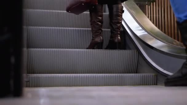 Benen van mensen bewegen op een roltrap lift in het winkelcentrum. Shoppers voeten op roltrap in het winkelcentrum — Stockvideo