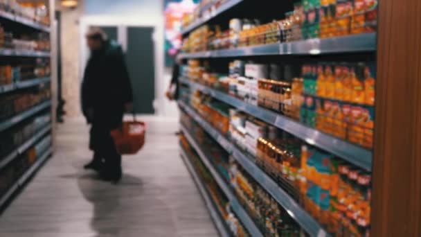 Reihen und Regale mit verschiedenen Produkten im Supermarkt. Käufer wählen das Produkt. — Stockvideo