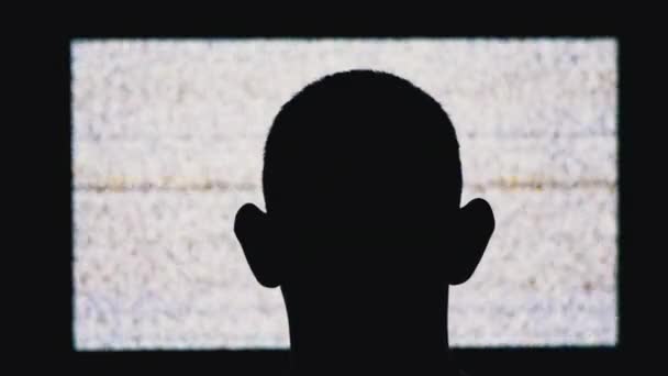 Silhouette of a Mans Head is Watching White Noise and TV Interference. — Stockvideo