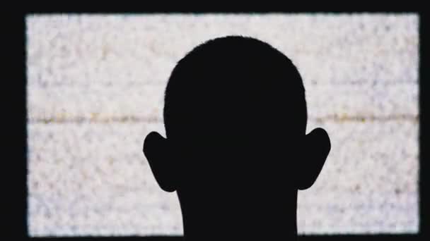 Silhouet van een Anonieme Mans Head kijkt naar White Static Noise en Tv Interference — Stockvideo