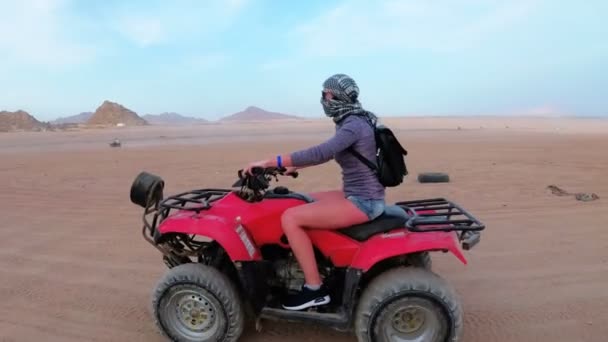 Kvinna rider en fyrhjuling i öknen i Egypten. Dynamisk vy i rörelse. — Stockvideo