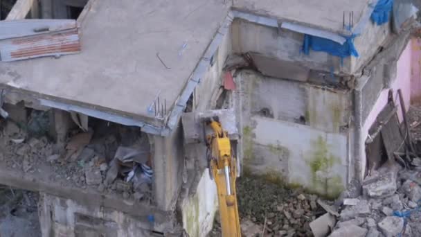 Destruyendo la vieja casa usando excavadora de cubo en el sitio de construcción . — Vídeo de stock