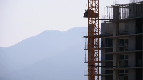 Tower Crane rakennustyömaalla nostaa kuorman korkeassa rakennuksessa . — kuvapankkivideo