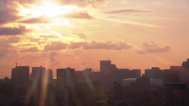 Вид с воздуха на строительные площадки, журавли и силуэты небоскребов на закате — стоковое видео