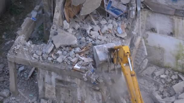 Destruindo a antiga casa de concreto usando braço mecânico de escavadeira no canteiro de obras — Vídeo de Stock