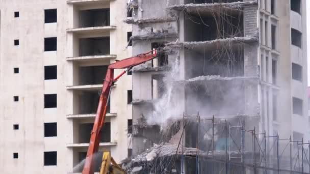 Distruggere la vecchia casa di cemento utilizzando il braccio meccanico del bulldozer sul cantiere — Video Stock