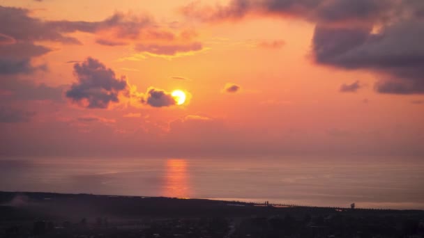Pôr do sol nas nuvens sobre o mar e a cidade, vista aérea . — Vídeo de Stock