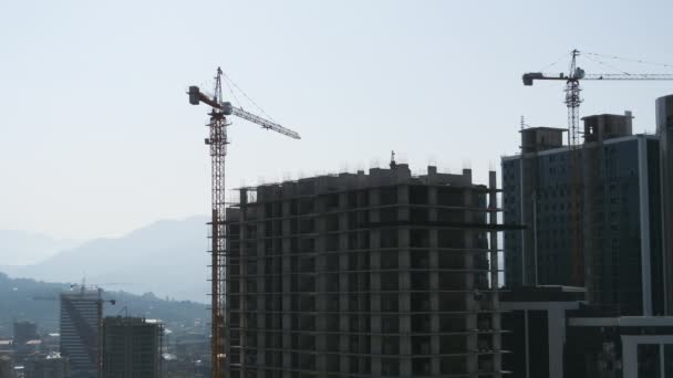 Tower Crane on a Construction Site Lifts a Load at High-rise Building. Timelapse. — Stock Video