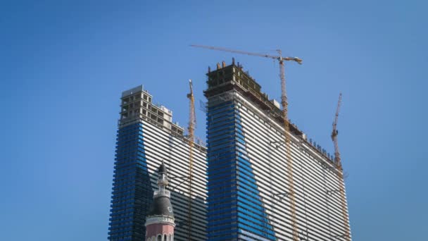 Tower Crane en un sitio de construcción levanta una carga en un edificio de gran altura. Cronograma . — Vídeos de Stock